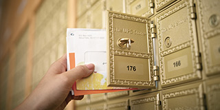 close up of hand taking mail from a mailbox